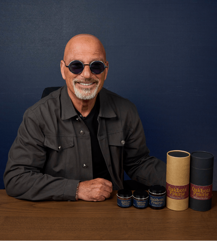Howie Mandel sitting with Dakhota Prairie products