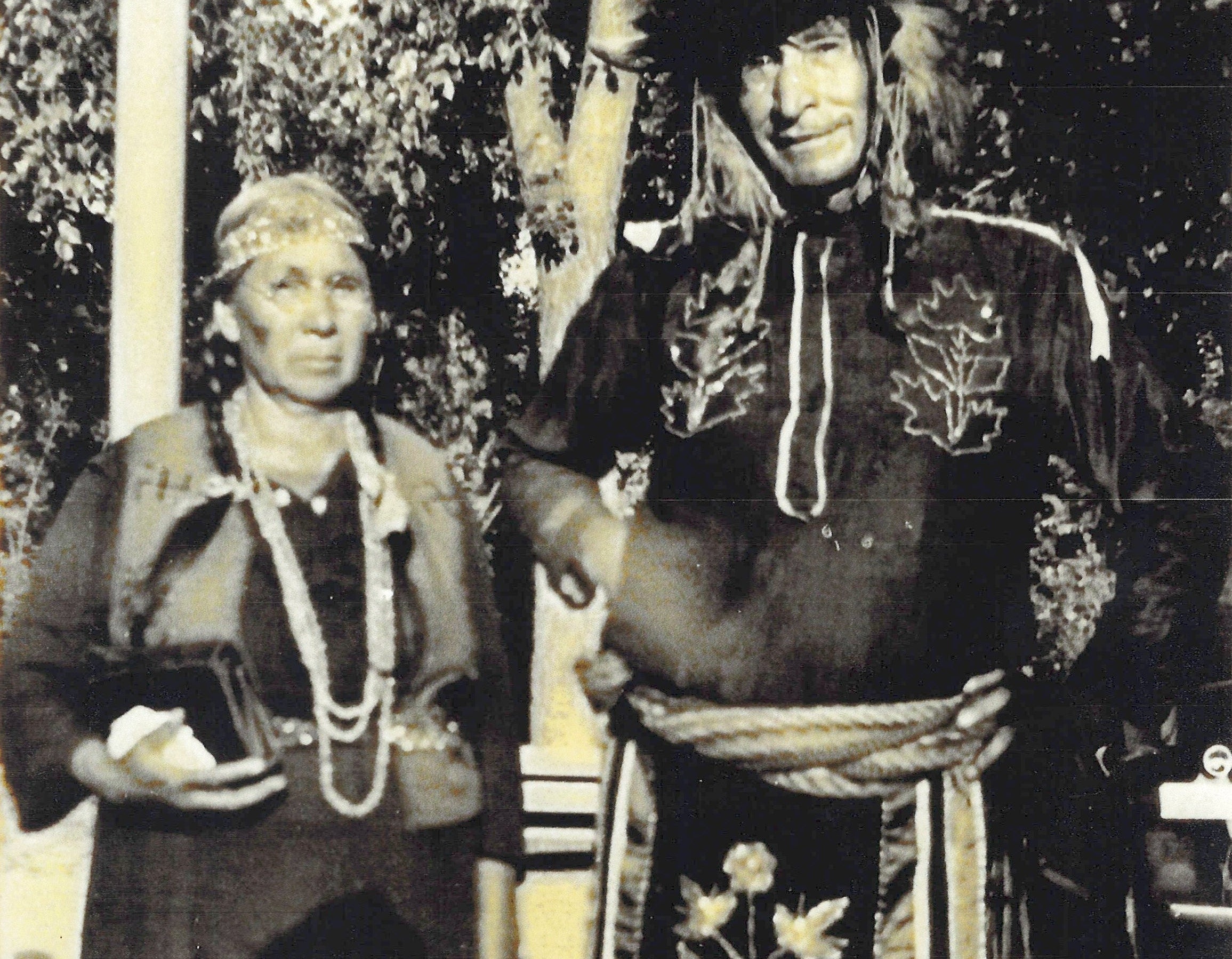 A black and white photo of the founders Native American relatives wearing their traditional attire.